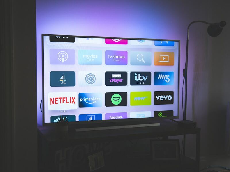 A large television displaying streaming apps in a dimly lit living room