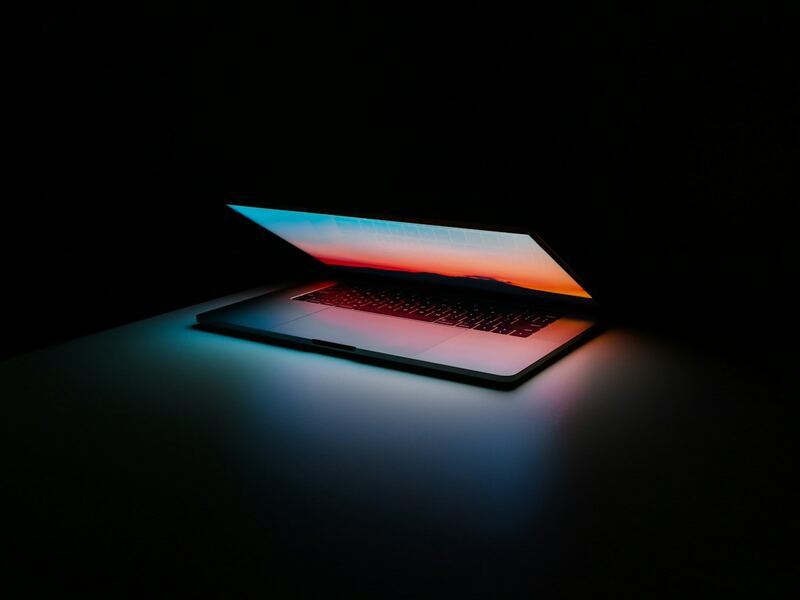A laptop glowing softly in a dark room, ready to connect